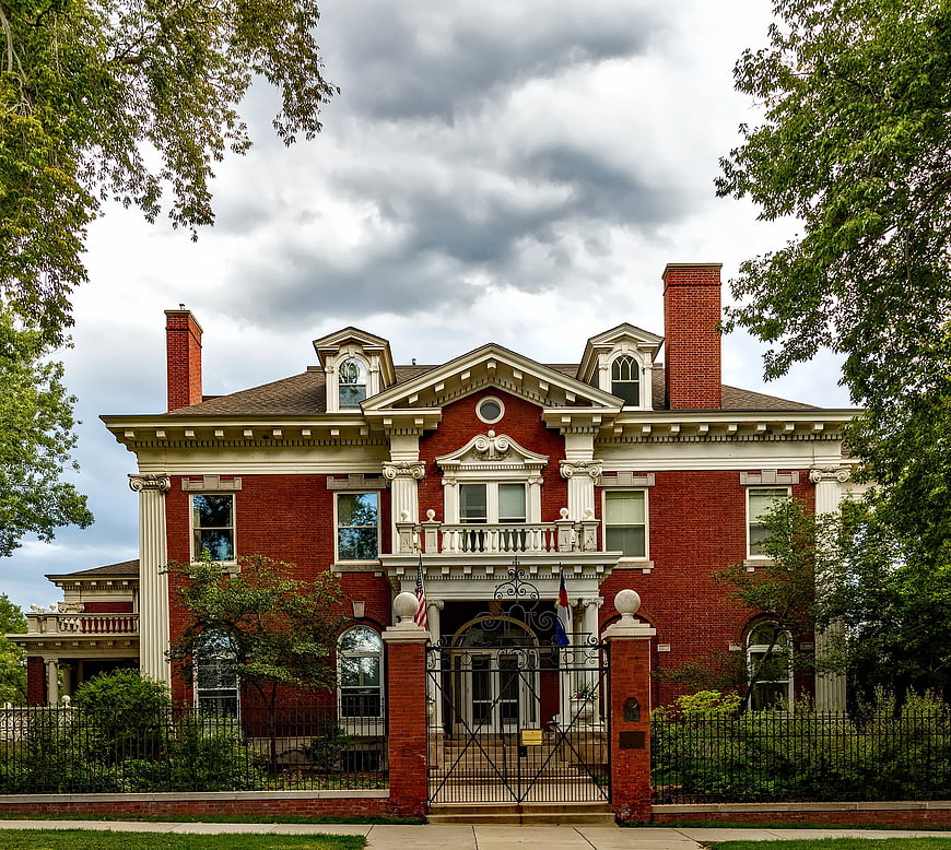 Grand Red Brick Mansion with White Columns and Ornate Details