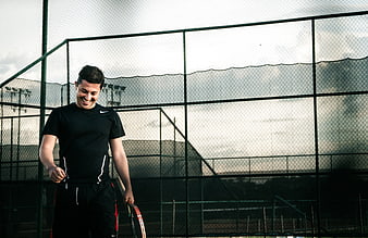 Happy Tennis Player Smiling on Court with Racket