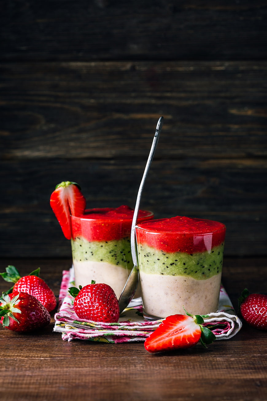 Layered Strawberry Kiwi Banana Smoothie Cups on Wood