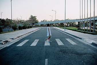 Woman in White Dress Walking on Empty Street