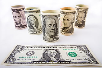 Rolled US Dollar Bills and One Dollar Note on White Background