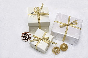 White and Gold Christmas Gifts in Snow with Pinecone