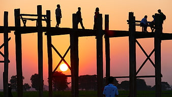 Silhouettes of people on U Bein Bridge at sunset
