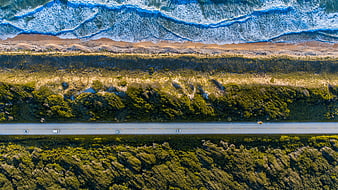 Aerial View of Coastal Highway with Ocean Waves and Forest