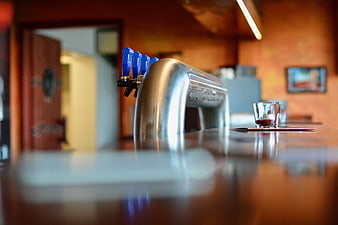 Close-up of beer taps on a polished wooden bar counter
