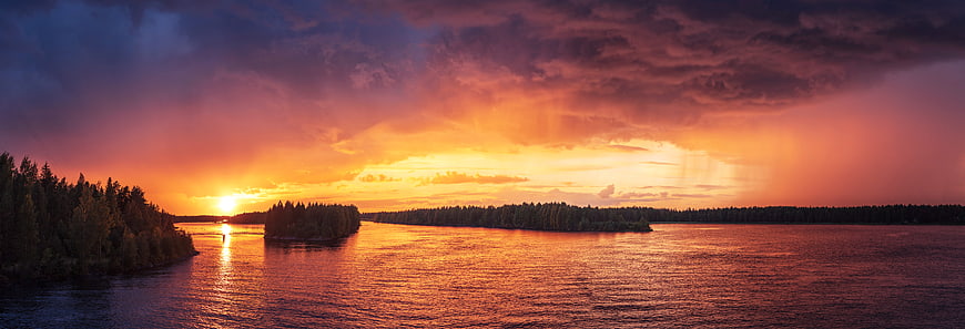 Dramatic Sunset Over River with Forested Islands and Golden Reflections