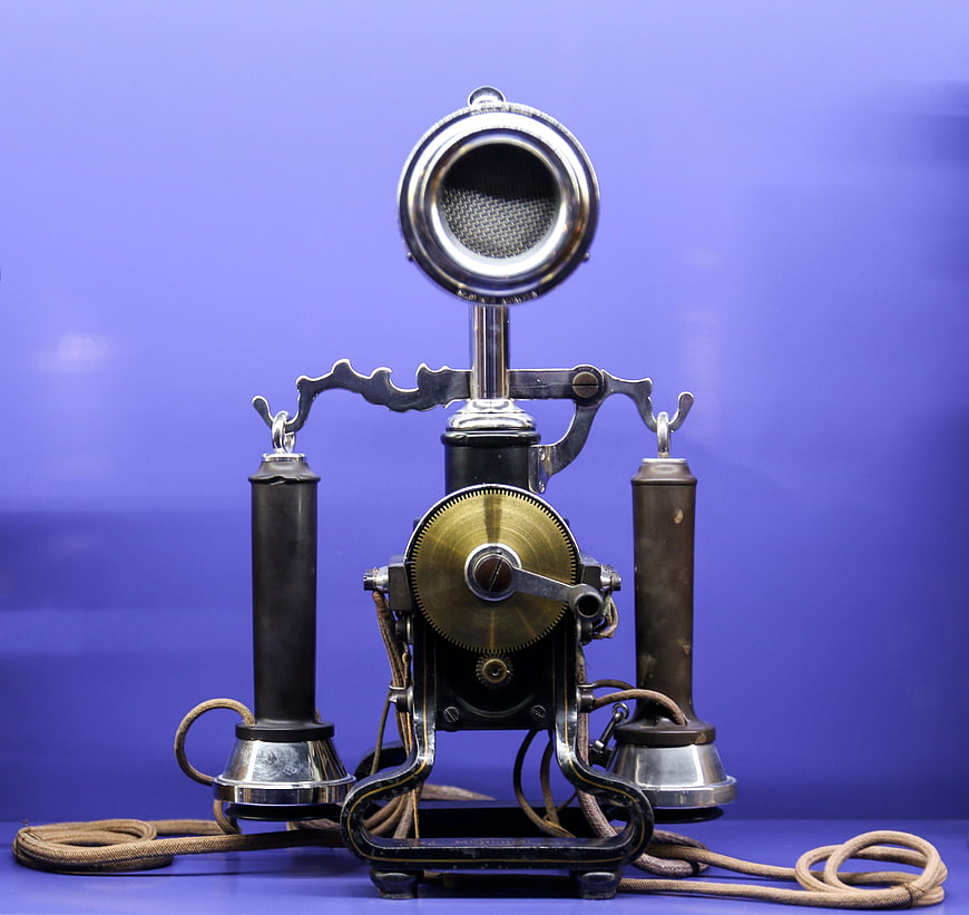 Vintage Antique Telephone with Brass Mechanism on Blue Background