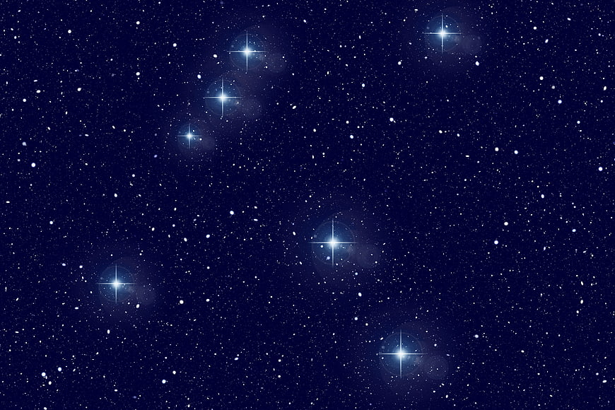 Deep blue starry night sky with bright starburst effects