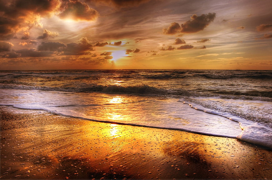 Dramatic Golden Sunset Over Ocean Waves on Sandy Beach