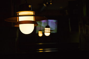 Modern pendant lamp with warm light in dark interior