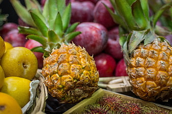 Fresh tropical pineapples and lemons at a fruit market