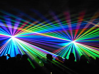 Vibrant multicolored laser light show with crowd silhouettes