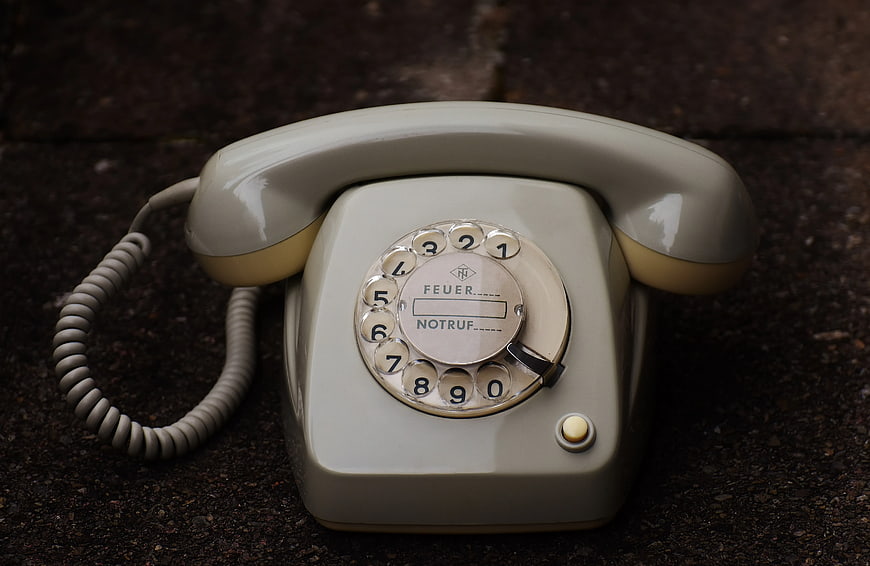 Vintage Gray Rotary Dial Telephone on Dark Surface