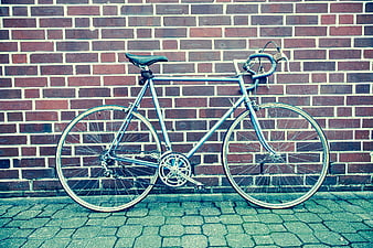Vintage Silver Bicycle Leaning Against Red Brick Wall