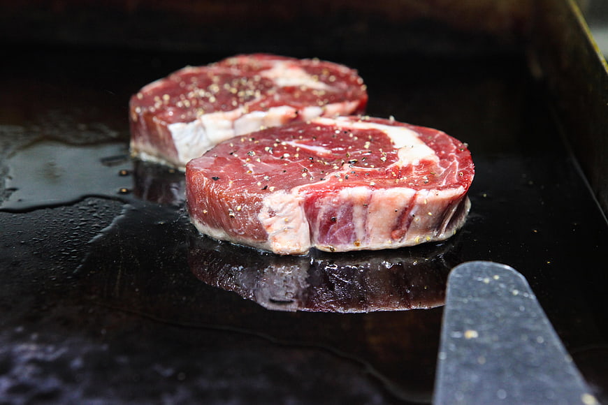 Raw Seasoned Filet Mignon Steaks Searing on Griddle