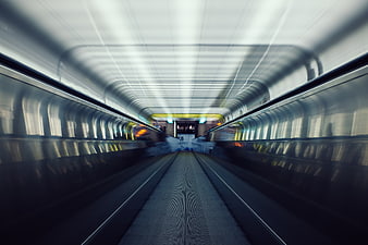 Motion blur escalator tunnel with leading lines and cool lighting