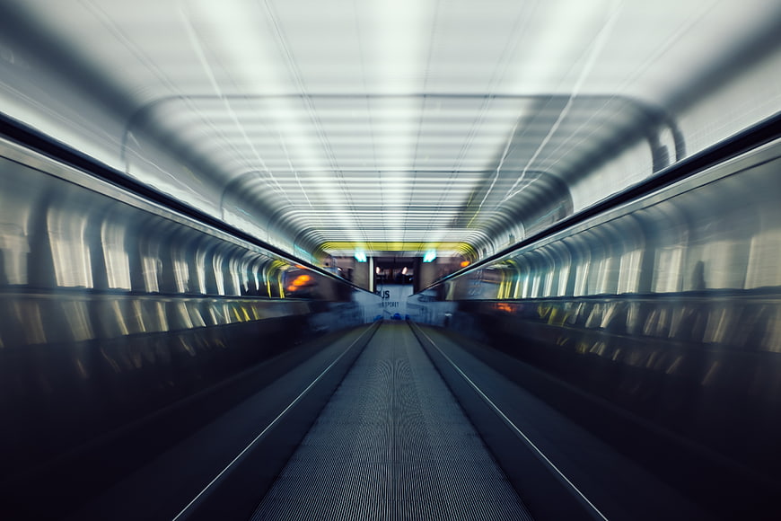 Motion blur escalator tunnel with leading lines and cool lighting