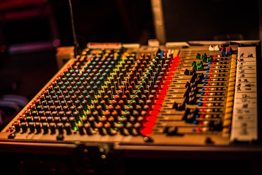 Close-up of professional audio mixing console with colorful knobs