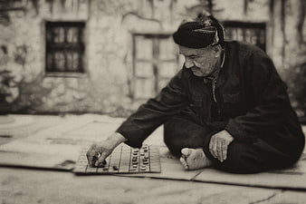 Elderly man playing traditional board game outdoors