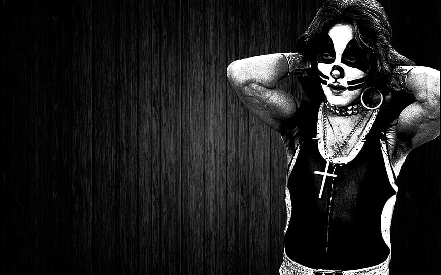 Woman with skull makeup and cross necklace against dark wood