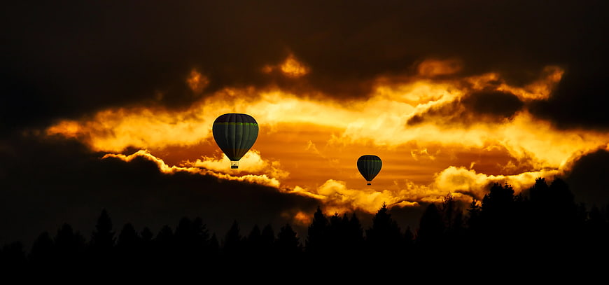 Hot Air Balloons Silhouetted Against Dramatic Sunset Sky