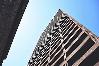 Low angle view of modern skyscraper against blue sky