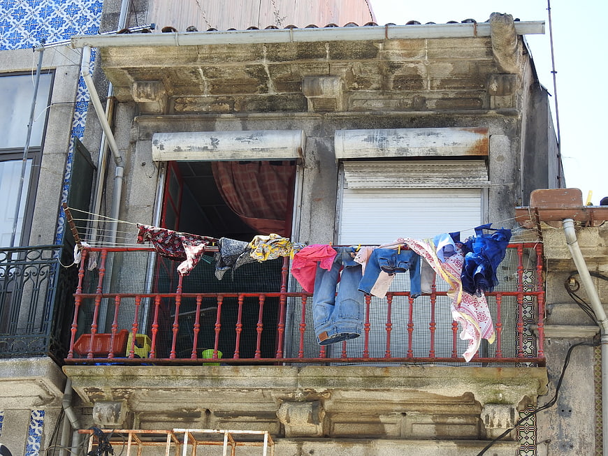 Laundry hanging on old European balcony with blue tiles