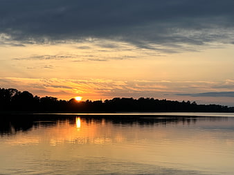 Serene Sunset Over Calm Lake with Golden Reflections