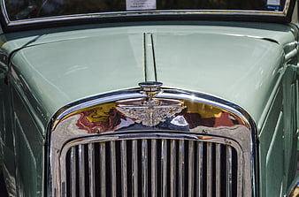 Close-up of vintage green car chrome grille and hood ornament