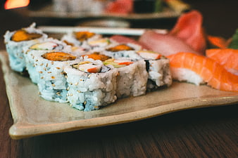 Assorted sushi rolls and nigiri on a ceramic plate