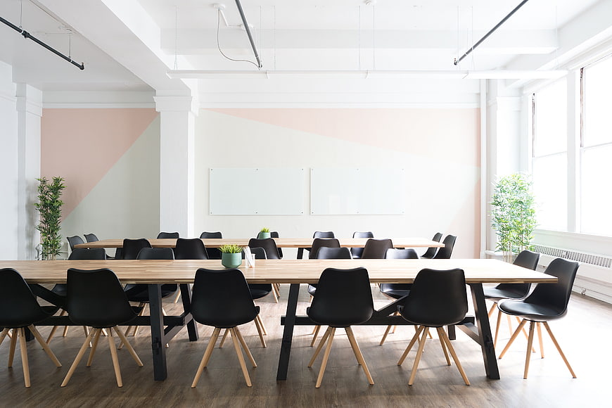 Modern Office Meeting Room With Wooden Tables And Black Chairs