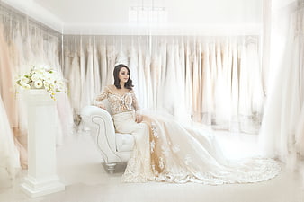 Elegant Bride in Lace Wedding Dress Sitting in Boutique