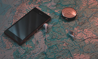 Vintage travel map with smartphone, compass, and headphones