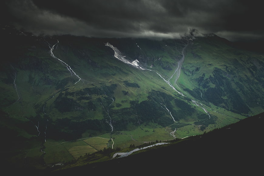Dramatic aerial view of green mountain valley with streams