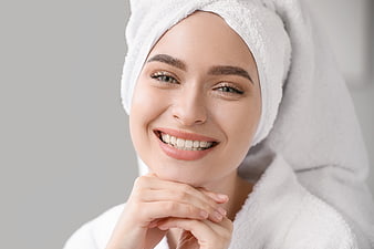 Happy woman with towel on head smiling after spa treatment