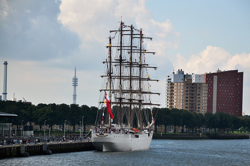 Historic sailing ship docked in Hamburg harbor with skyline