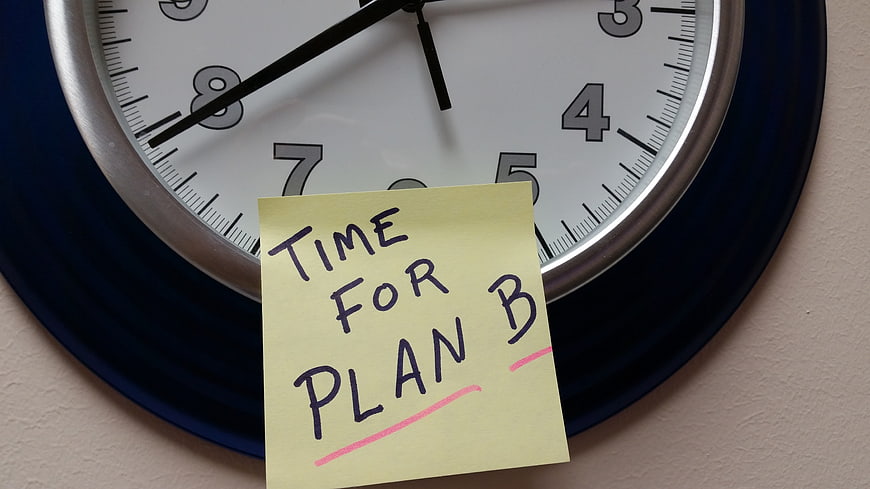 Yellow sticky note reading Time For Plan B on a wall clock