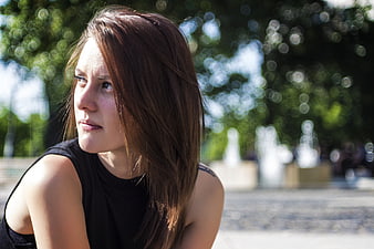 Thoughtful young woman with brown hair in park