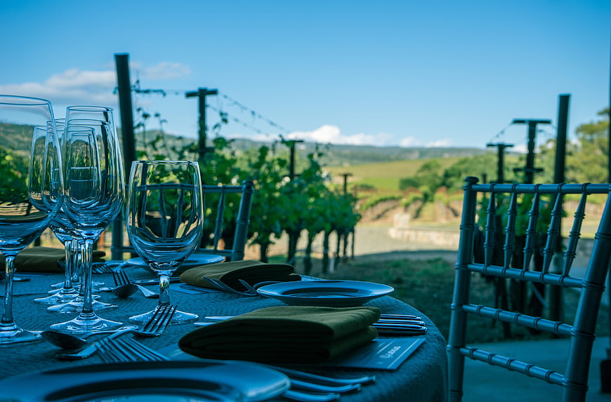 Elegant outdoor dining table set in a scenic vineyard landscape