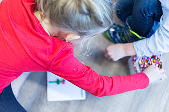 Children Playing with Beads on Floor