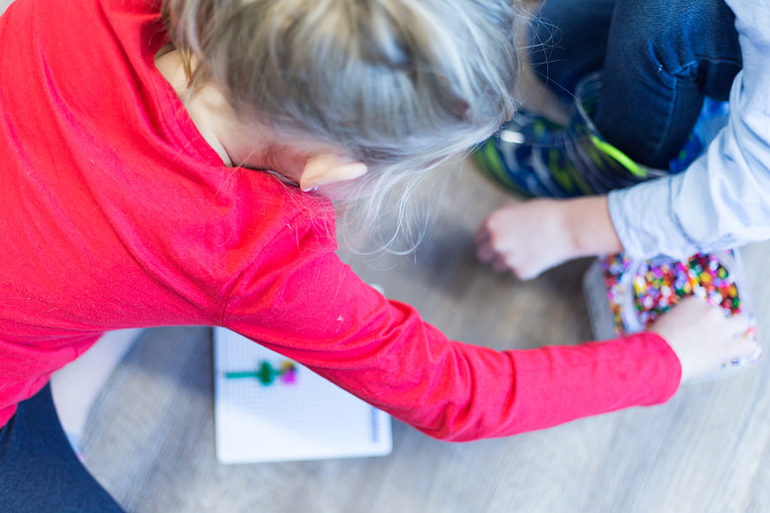Children Playing with Beads on Floor