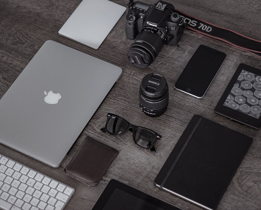 Flat lay of photographer workspace with camera, laptop, and accessories