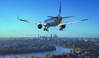 Commercial Airplane Landing Over City Skyline And River