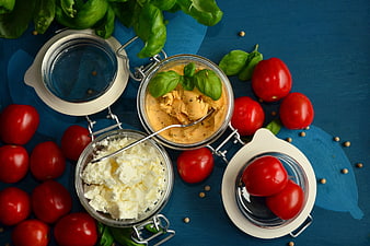 Fresh Tomatoes, Feta Cheese, and Basil in Glass Jars on Blue Background