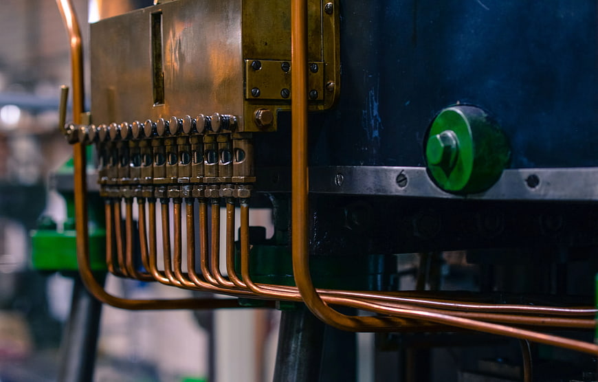 Close-up of industrial machine with copper pipes and brass fittings