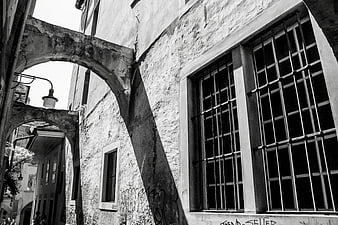 Black and White Photo of Old Stone Archway and Barred Windows