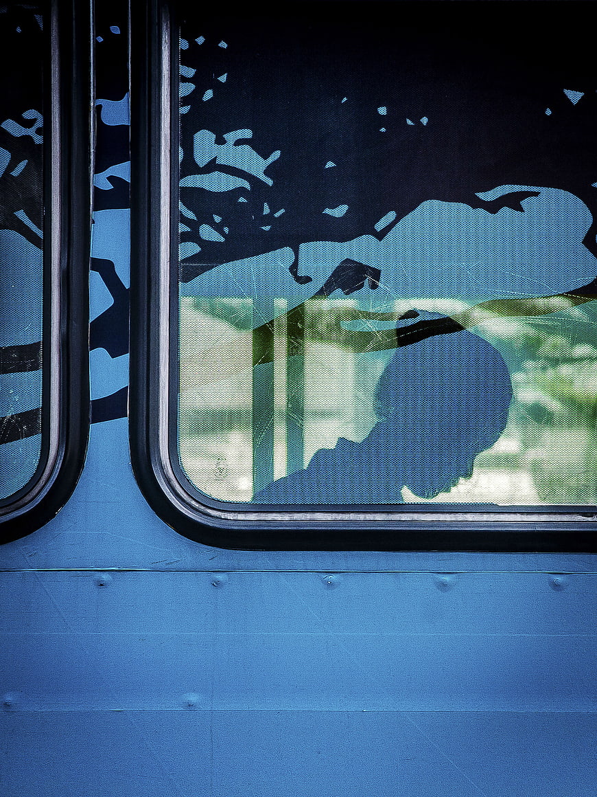 Silhouette of Passenger in Blue Train Window