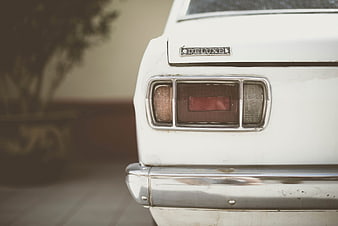 Close-up of vintage white car rear with chrome bumper