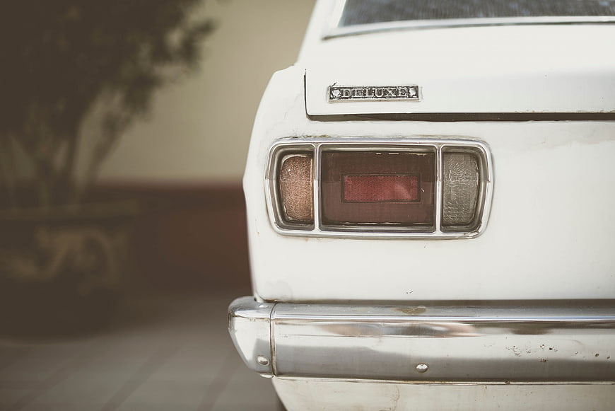 Close-up of vintage white car rear with chrome bumper