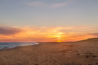 Serene Beach Sunset with Golden Sky and Sandy Shore